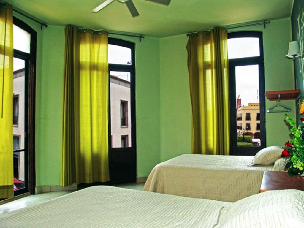 Bright guest room with windows at Hotel Plaza Querétaro